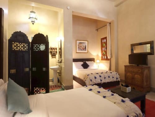 Chambre triple à la Villa El Gada Marrakech avec lits jumeaux, mobilier en bois foncé, décor marocain et salle de bain attenante