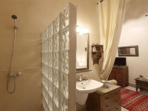 Salle de bain de la Suite Triple Supérieure à Villa El Gada, Marrakech, avec paroi de douche en verre dépoli, lavabo, toilettes et