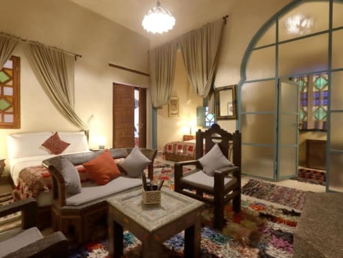Chambre Quadruple Supérieure à la Villa El Gada à Marrakech avec lit, coin salon, décor traditionnel et équipements modernes