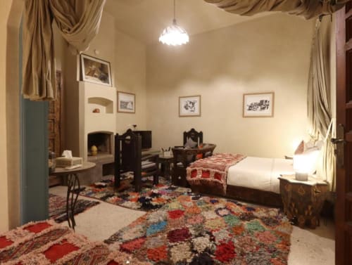 Chambre Quadruple Supérieure à Villa El Gada Marrakech avec décoration traditionnelle, cheminée, lits et tapis colorés