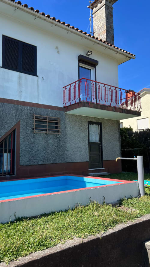 Villa Casa do Sol Norte em Gemeses com piscina privada, vista para jardim e residência de pedra branca de dois andares com varanda vermelha