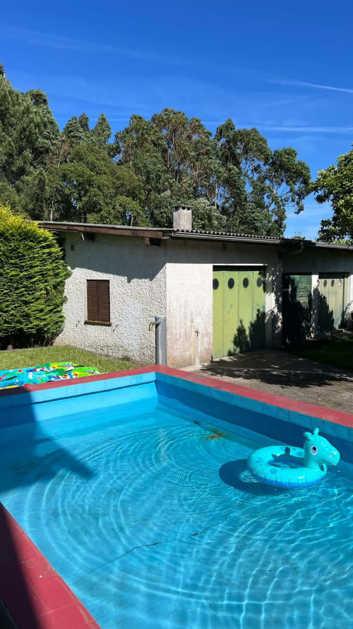 Piscina privada azul vibrante com flutuador inflável no jardim ensolarado da Villa Casa do Sol Norte, Gemeses Portugal