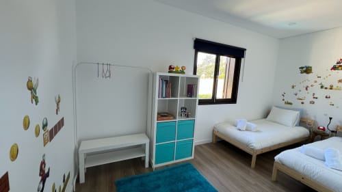 Quarto infantil luminoso da villa Casa do Sol Norte em Gemeses com duas camas, móvel turquesa, escrivaninha e vista para o jardim