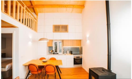 Cozinha moderna com mesa de jantar e cadeiras laranja na villa Casa Lobos, Remote Care & Co, Vieira do Minho