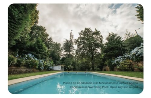 Piscina do condomínio circundada por jardins verdes exuberantes na villa Casa Lobos em Vieira do Minho, aberta julho-agosto