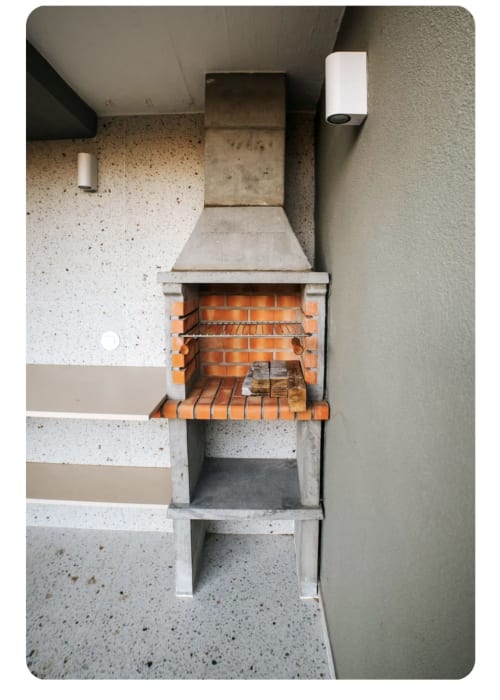 Churrasqueira de alvenaria ao ar livre com chaminé metálica na villa Casa Lobos em Vieira do Minho