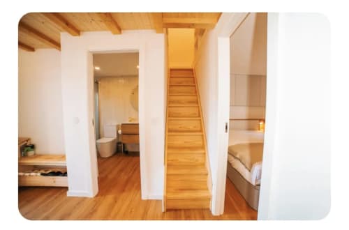 Interior da quinta Casa Lobos com escadas de madeira, quarto, casa de banho e vigas de madeira em Vieira do Minho