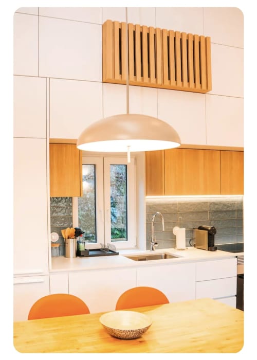 Cozinha moderna da villa Casa Lobos com acabamentos em madeira, luminária pendente e área de refeições com vista para o jardim