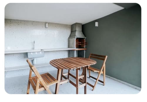 Área de jantar exterior moderna na villa Casa Colina em Salamonde com mesa de madeira, cadeiras e churrascaria de tijolos