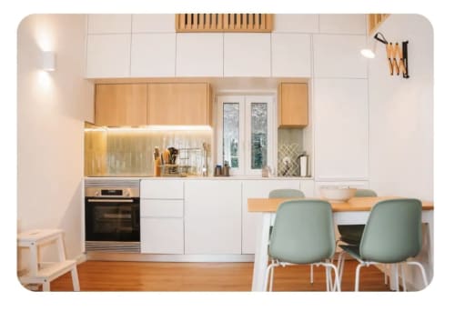 Cozinha e sala de jantar modernas na villa Casa Colina com acabamentos em madeira, marcenaria branca e cadeiras verde sálvia