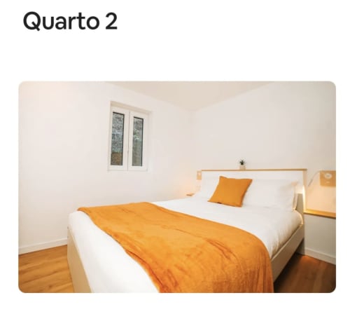 Quarto luminoso na villa Casa Colina em Salamonde com cama queen, acentos laranja, piso de madeira e vistas para a montanha
