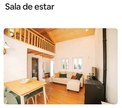 Sala de estar luminosa da villa Casa Colina em Salamonde com sofá bege, mesa de jantar, loft em madeira e vistas para a serra