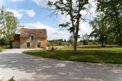 Villa en pierre rustique avec chaises Adirondack sur les pelouses de Maisons Noisette, Saint-Pierre-des-Ormes, France