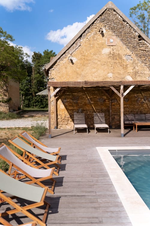 Piscine chauffée et chaises longues à la villa Maisons Noisette à Saint-Pierre-des-Ormes avec bâtisse en pierre