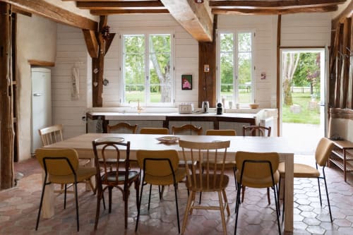 Cuisine ouverte lumineuse et salle à manger de la villa Maisons Noisette en Perche, avec poutres en bois et décor rustique