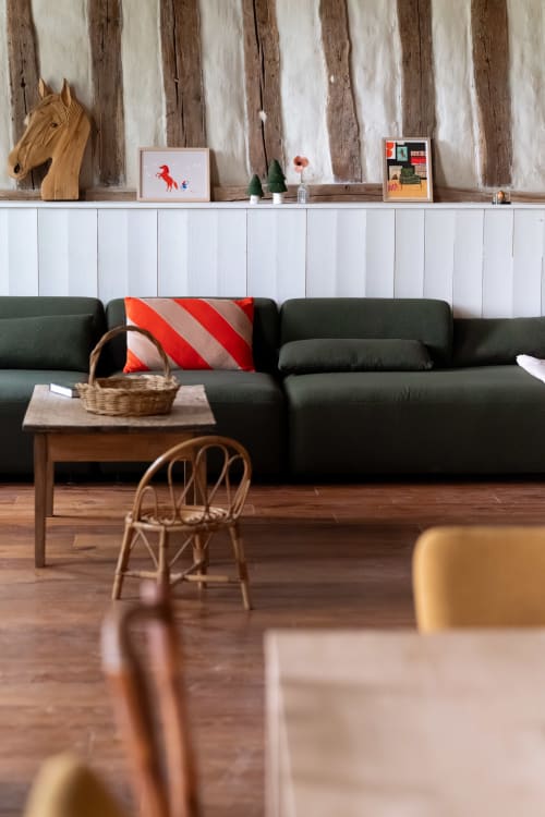 Salon moderne de Maisons Noisette avec canapé foncé, mobilier en bois et décoration rustique à Saint-Pierre-des-Ormes