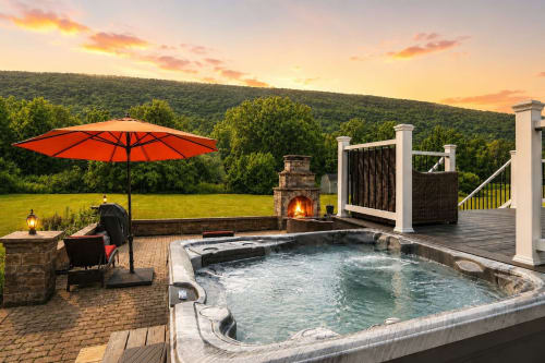 Luxury mountain view villa with hot tub, fireplace, and sunset over forested hills at Malkita Aria in Woodbury