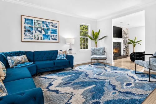 Modern villa living room with blue sectional sofa, geometric rug, and mountain views at Malkita Aria in Woodbury
