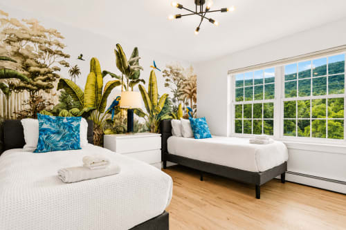 Malkita Aria villa bedroom in Woodbury with twin beds, tropical decor, mountain views through large windows