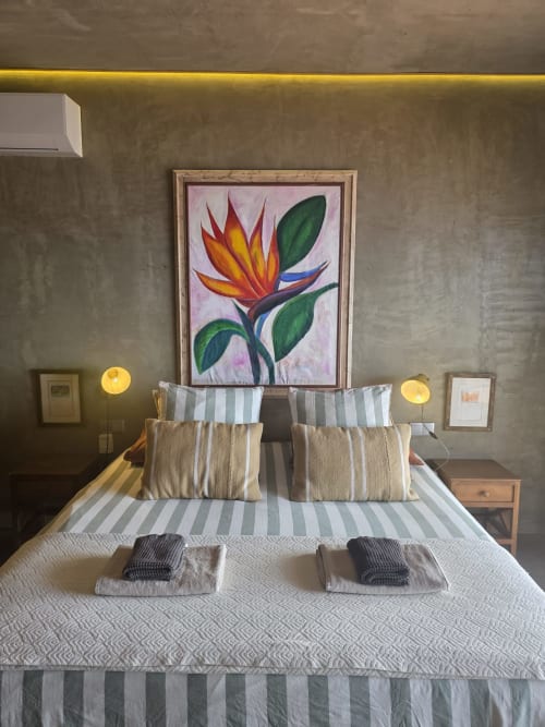 Quarto moderno em Les Terrasses Les Suites Calheta com roupa de cama listrada, obra de arte com ave do paraíso e iluminação ambiente
