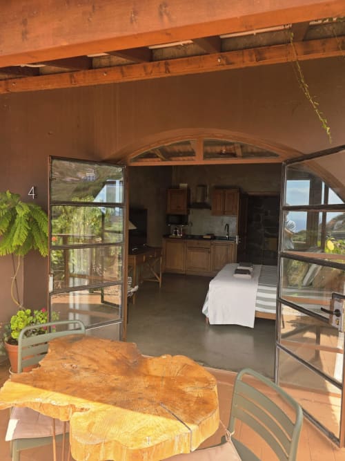 Suite 4 em Les Terrasses Les Suites em Calheta com terraço aberto, mesa de madeira, cozinha e vistas para a montanha