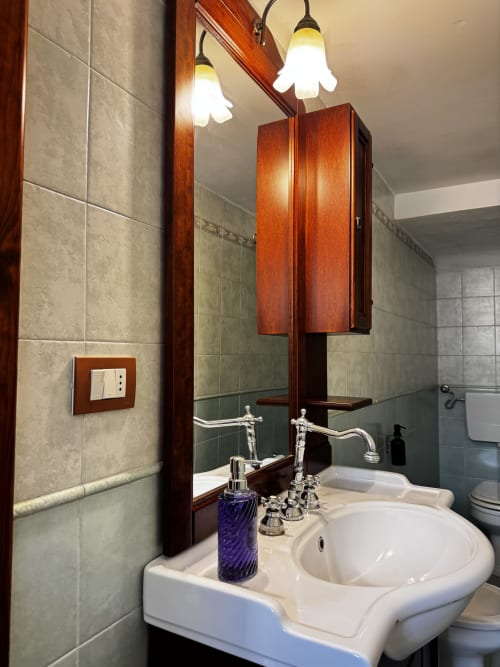 Elegante bagno di HABITARE Lecce con doppio lavabo, specchiera in legno e raffinati elementi di illuminazione nel Salento