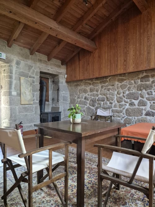 Rustic apartment dining area at Aldea Rural Pazos De Arenteiro with stone walls, wooden beams, and mountain views