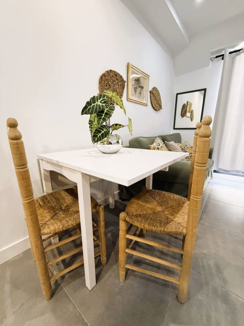 Comedor moderno con mesa blanca, sillas de madera y planta verde en lujoso apartamento frente al mar en Fuengirola