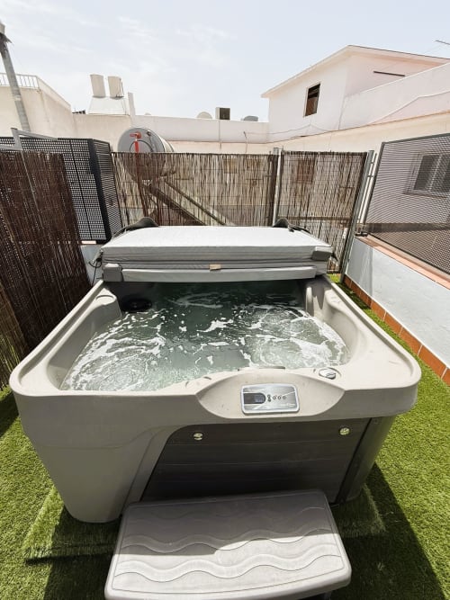 Lujosa bañera de hidromasaje burbujeante en terraza con vista al mar del apartamento en Fuengirola, con cerco de seguridad
