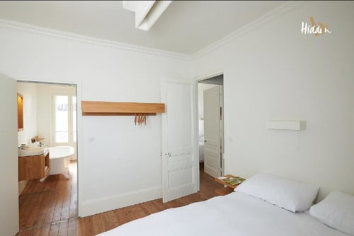 Bright bedroom in Suite Juliette at Hidden Bay Hotel, Cayeux-sur-Mer, with wooden floors, white walls, and ensuite bathroom