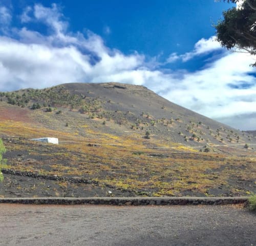 Paisaje volcánico con vegetación dispersa y edificio blanco, La Palma Islas Canarias