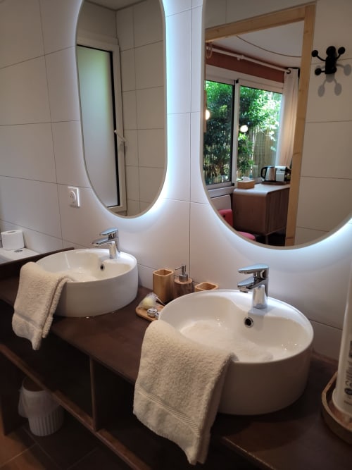 Bagno moderno con doppio lavabo, specchi illuminati e mobile in legno nella camera Sweet Bubble del Le Lodge du Cap Ferret