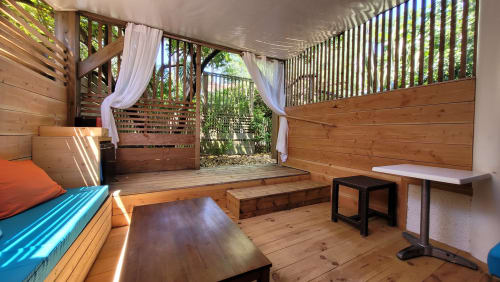 Spaziosa camera da letto in legno con vista sul giardino, letto piattaforma, scrivania e terrazza privata al Lodge du Cap Ferret