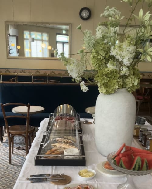 Salle à manger de l'Hôtel Hidden Bay avec composition florale blanche, buffet et élégance côtière française à Cayeux-sur-Mer