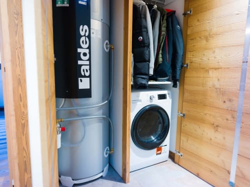 Buanderie de l'appartement Sage des Montagnes à Montgenevre, avec chauffe-eau Baldes et lave-linge blanc