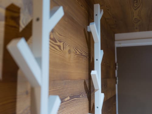 Rampe d'escalier en métal blanc et lambris en bois dans l'appartement Sage des Montagnes aux Tanières de Montgenèvre