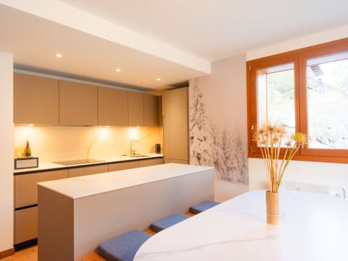 Cuisine moderne avec îlot blanc et armoires en bois dans l'appartement Sage des Montagnes, station de ski de Montgenèvre
