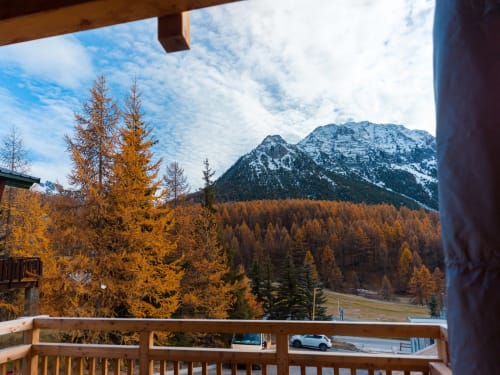 Vue depuis la terrasse sur les mélèzes dorés et les montagnes enneigées de la station de ski de Montgenèvre
