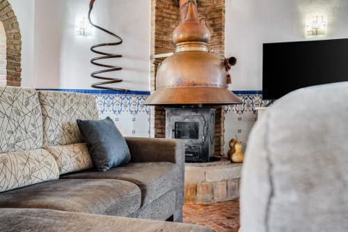 Cozy living room at Quinta do Águas villa in Lagoa with fireplace, patterned sofa, and copper hood detail