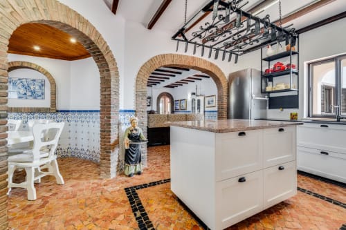 Modern villa kitchen with brick archways, white cabinetry, and terracotta tile flooring at Quinta do Águas, Lagoa Portugal