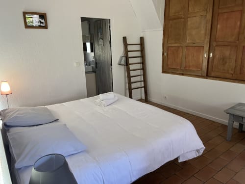 Chambre spacieuse du gîte Les Vaches à La Jument Verte, Trévignin, avec literie blanche et meubles en bois