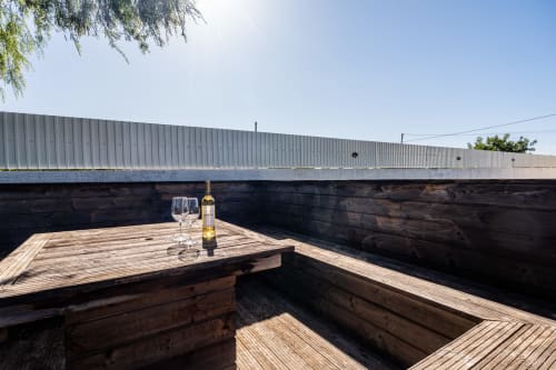 Wine bottle and glasses on wooden deck overlooking private pool at Quinta do Águas villa in Lagoa, Portugal