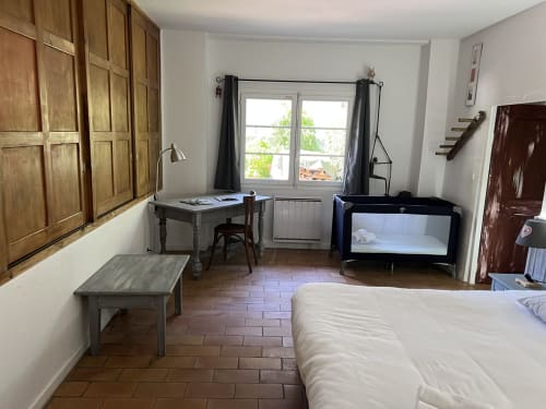Chambre spacieuse à La Jument Verte avec armoire en bois, bureau, lit, lit bébé et vue sur fenêtre à Trévignin