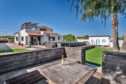 Quinta do Águas villa in Lagoa with pool view, wooden deck, BBQ area, manicured lawn, and modern white architecture