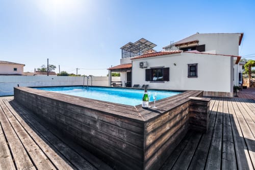 Quinta do Águas villa pool view in Lagoa with wooden deck, private swimming pool, and white villa with terracotta roof