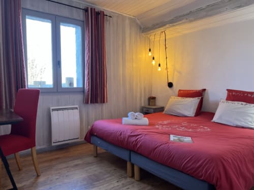 Chambre de charme avec literie rouge, luminaires suspendus et vue sur les montagnes à LA JUMENT VERTE, Trévignin