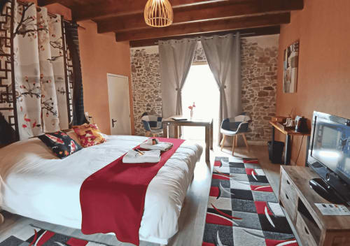 Sakura-Schlafzimmer im La Synchronicité B&B mit Gartenblick, rote Akzente und traditionelle Steinmauern