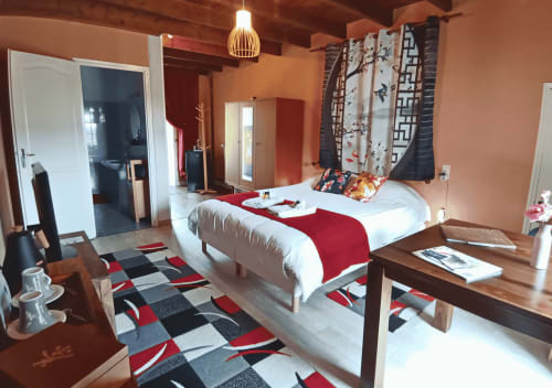 Sakura-Schlafzimmer im La Synchronicité B&B mit weißem Bett, roten Akzenten, Gartenblick und modernem Komfort
