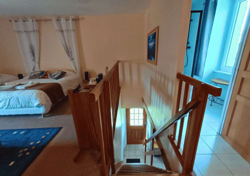 Houten trap in Studio de l'Écureuil op La Synchronicité B&B in Saint Sauveur, Frankrijk, met zichtbare slaapkamer