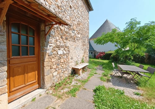 Stenen cottage met houten deur en tuinzithoek bij La Synchronicité, Saint Sauveur Villages
